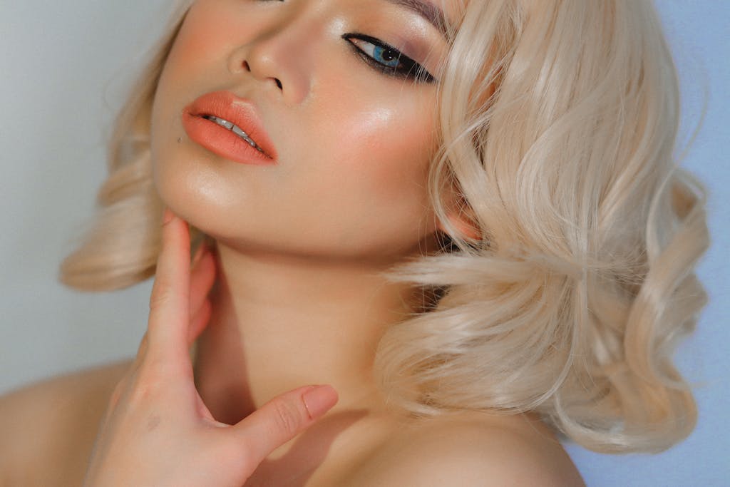 A captivating studio portrait of a blonde woman with glamorous makeup and elegant style.