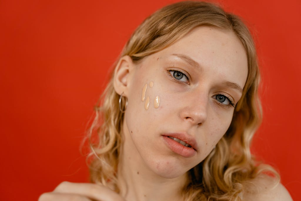 A close-up portrait of a woman applying foundation, showcasing natural beauty and skincare.