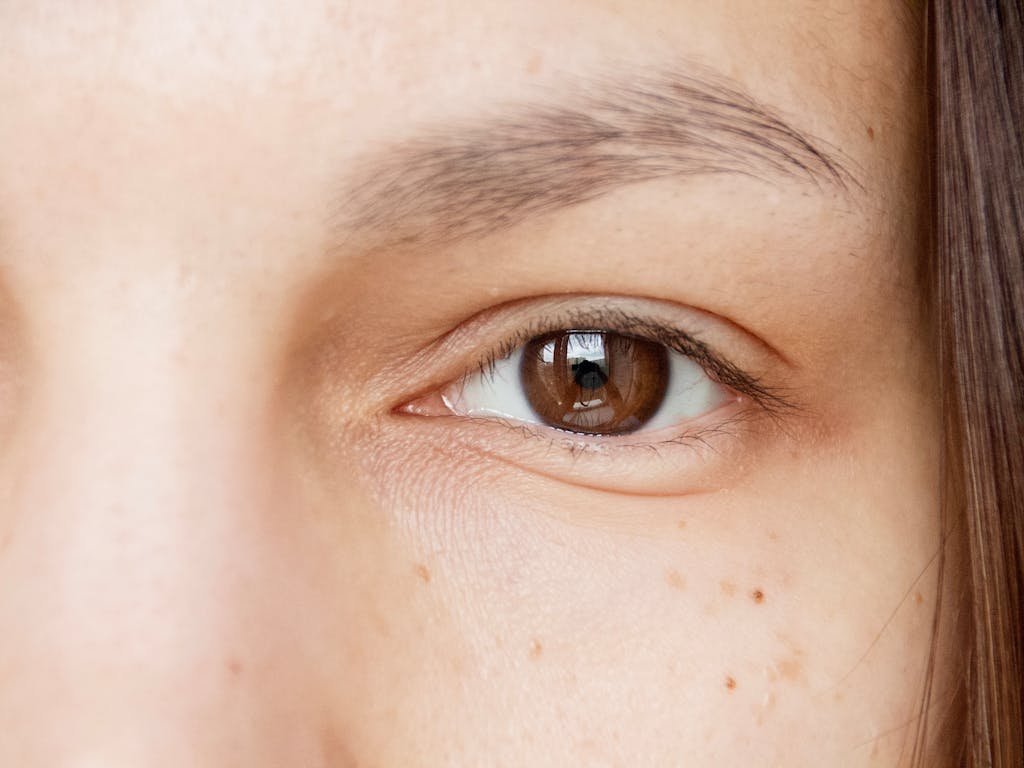 A detailed close-up of a brown eye, showcasing natural textures and reflections.