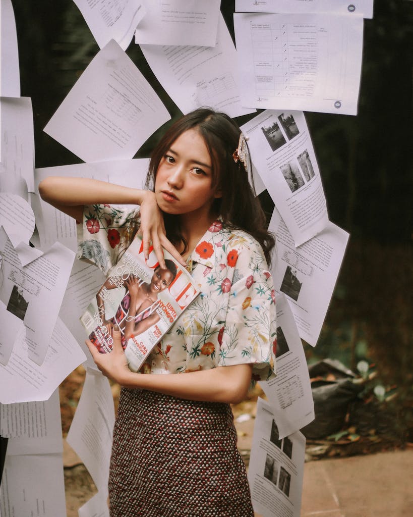 Artistic portrait of a woman surrounded by papers outdoors in Sumatra, Indonesia.