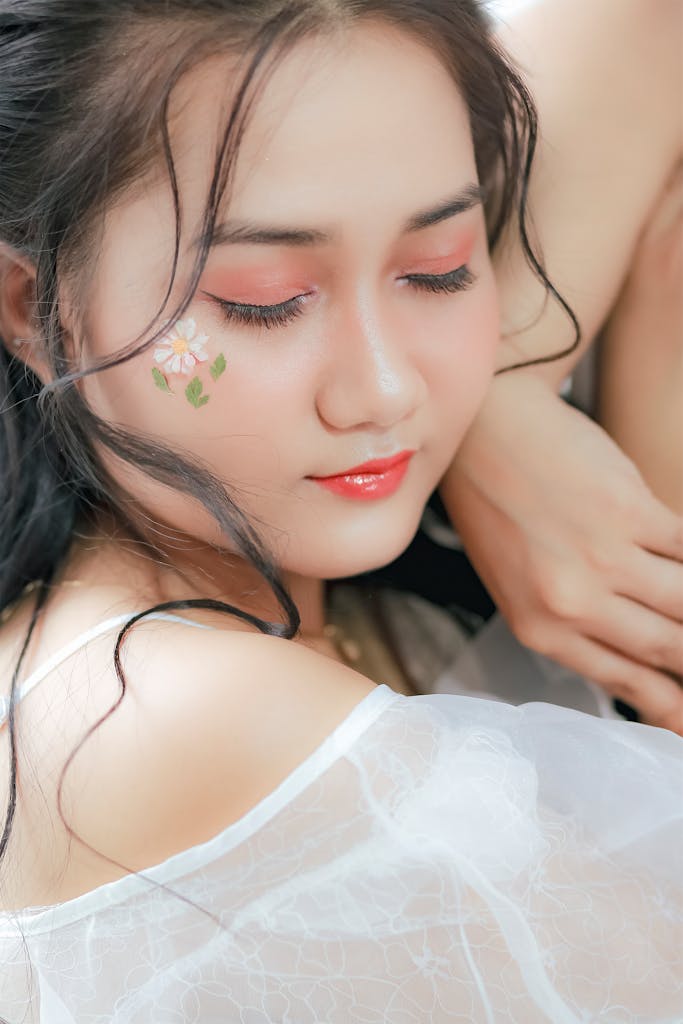 Close-up portrait of a woman with floral makeup and serene expression, ideal for beauty and fashion themes.