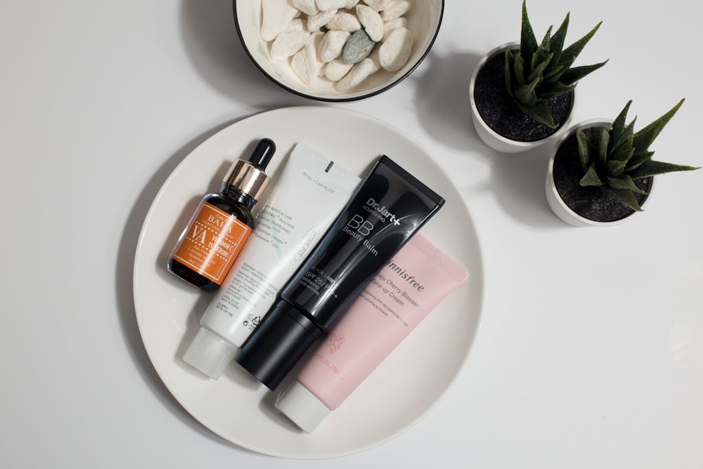 Elevate your skincare routine with this minimalist product display featuring various cosmetics on a white plate.