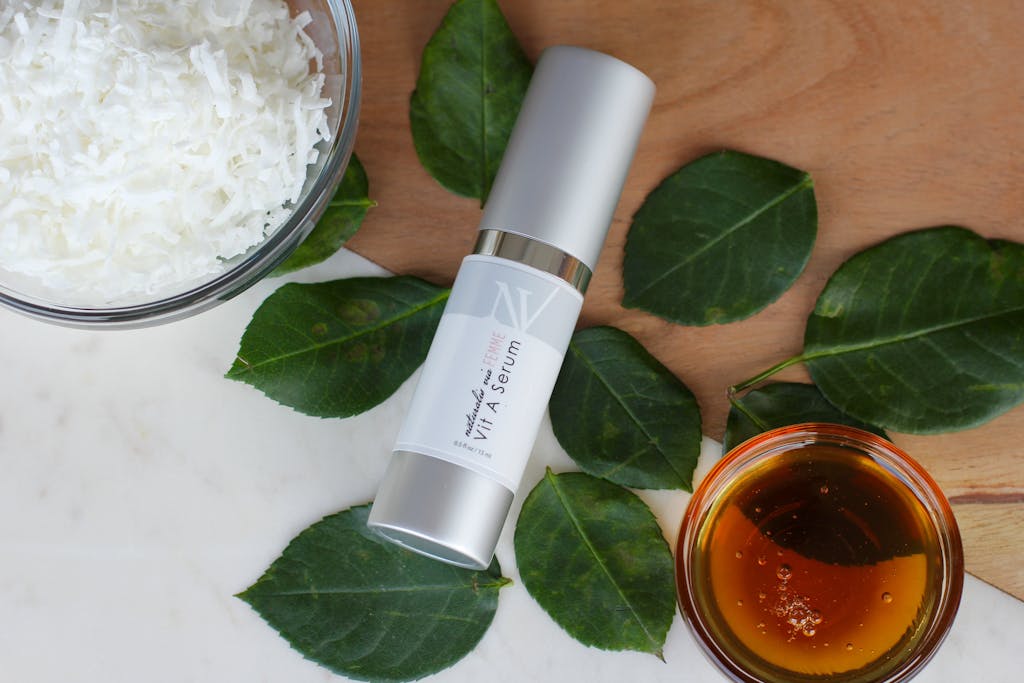 Top view of a natural vitamin A serum with honey, coconut, and leaves.